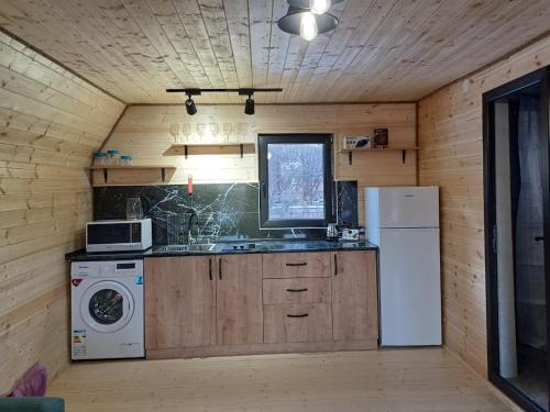 SnoPanorama cottages in Sno的厨房配有洗衣机、水槽和冰箱。