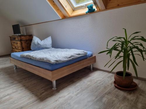 黑尔博尔茨海姆Haus Ziegenblick的一间卧室配有一张床和盆栽植物