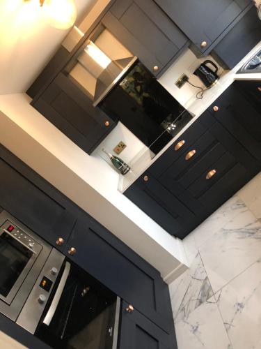 普雷斯顿Stunning 2 bedroom apartment的厨房配有黑色橱柜和大理石台面