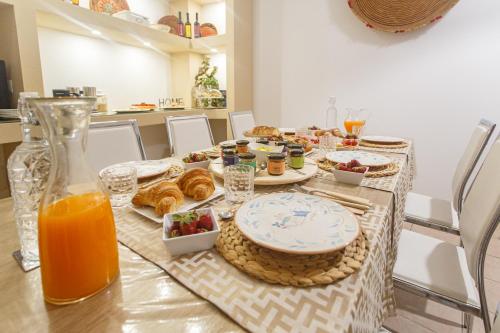 圣安蒂奥科Montellino's Suite Oro的一张桌子,上面有早餐食品和橙汁