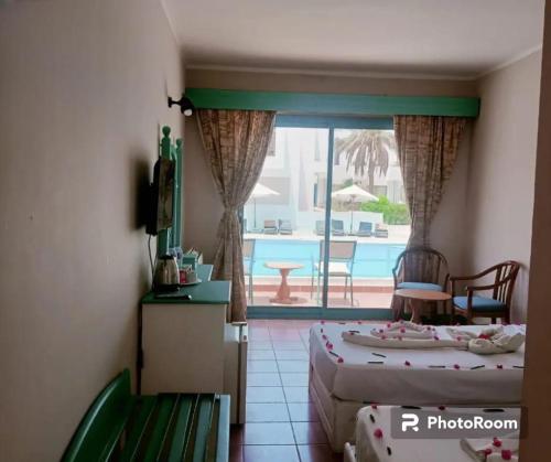 沙姆沙伊赫Badawia Sharm Resort的一间卧室设有两张床,享有游泳池的景色