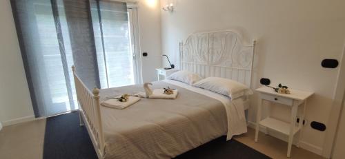 多马索My Holiday - Alessandra Residence - Domaso的卧室配有白色的床和2条毛巾
