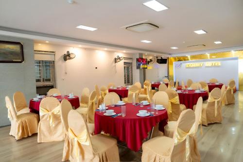 Giáp Vinh YênSAMMY Hotel - Khách sạn SAMMY的宴会厅配有红色桌椅和屏幕