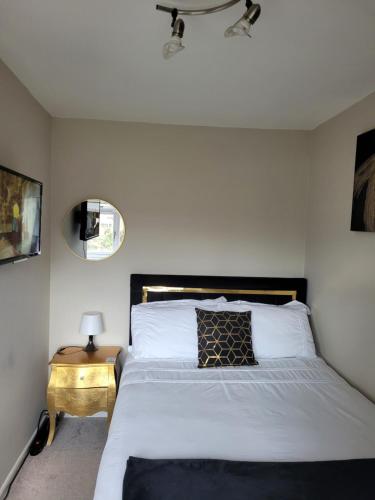 ShevingtonNB's Cozy Nook的一间卧室配有一张床和一张带镜子的边桌