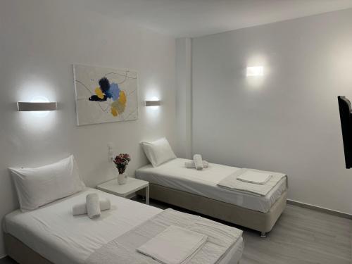 爱琴娜岛Central Suites Aegina 4的一间卧室设有两张床,墙上挂着一幅画