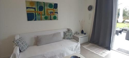 LeggiunoMirasole Holiday House的客厅配有白色沙发和绘画作品
