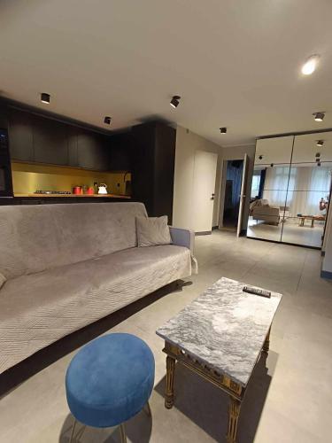 罗兹DWUPOKOJOWY APARTAMENT 51 m2的带沙发和蓝色凳子的客厅