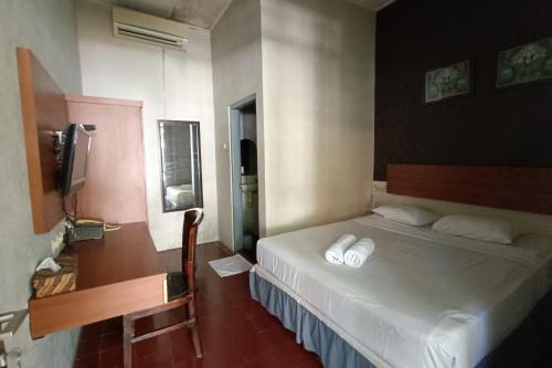 日惹纳尔姆曼特里加温酒店的酒店客房,配有床和电视