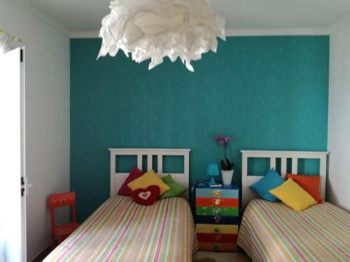 Praia VerdeCasa Bambu, Paraiso na Terra的一间卧室设有两张床和蓝色的墙壁