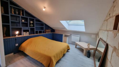 索米尔Duplex cosy dans la rue des caves à vin的阁楼卧室配有床和天窗