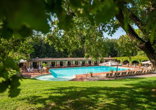 蒙特里久尼博尔戈圣路易吉酒店的树木繁茂的公园内的游泳池