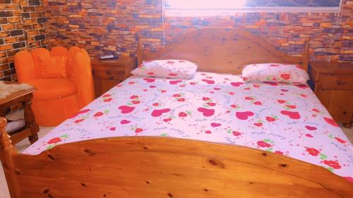 济金绍尔La fierté的一间卧室配有一张带鲜花的木床