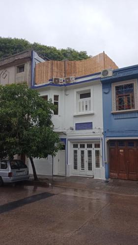 蒙得维的亚Casa Triada的蓝色和白色的房子,前面有停车位