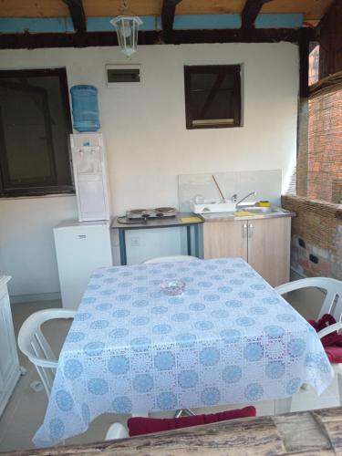 格拉迪什卡Apartmani Primus的厨房配有蓝色和白色的桌椅