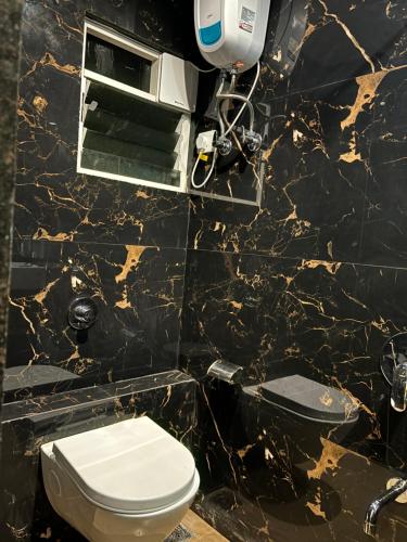 那格浦尔Airport Hotel Relax Inn的一间带卫生间和黑色大理石墙的浴室