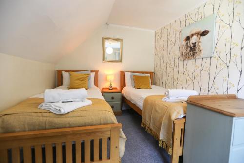 林茅斯Ferndale Cottage的一间阁楼卧室,房间内设有两张床