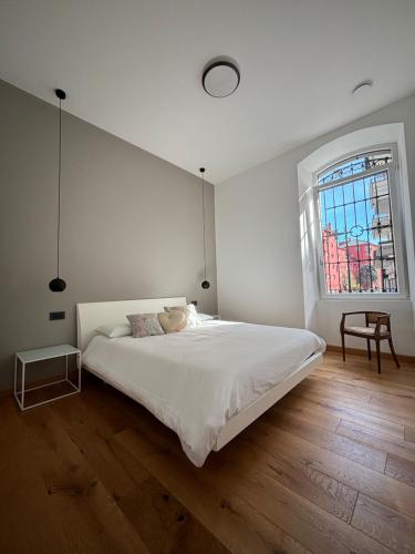 多莫多索拉Residenza la Torretta的白色的卧室设有一张大床和一个窗户