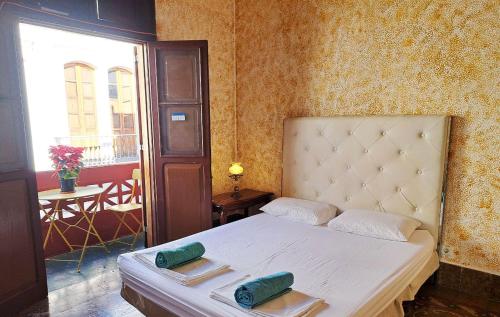 大加那利岛拉斯帕尔马斯Stardust House Vegueta的一间卧室配有一张床,上面有两条毛巾