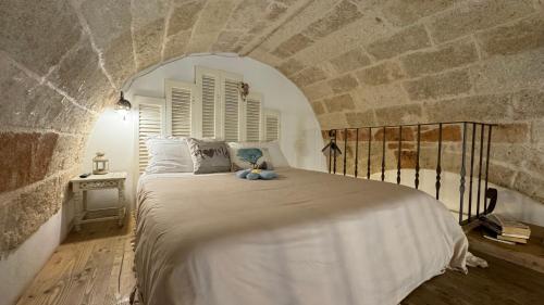 滨海波利尼亚诺卡萨菲奥雷住宿加早餐酒店的卧室配有一张石墙内的大床