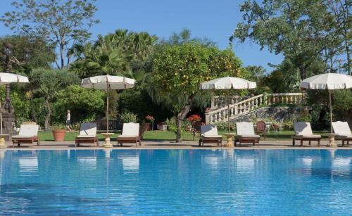 卡拉塔比亚诺圣马可城堡魅力Spa酒店的游泳池旁设有躺椅和遮阳伞的游泳池
