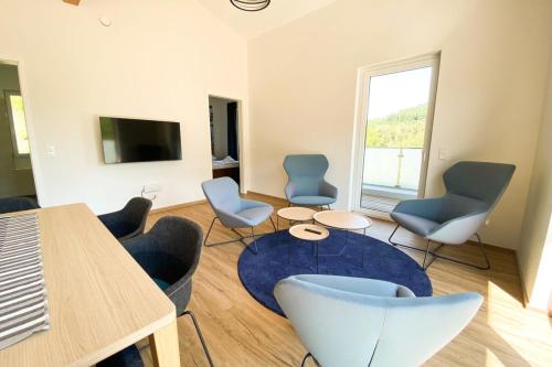 博福特310 Lux Furnished flat的客厅配有椅子、桌子和电视