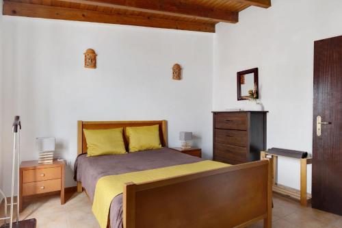 里戈尔Casa dos Peixinhos - Rogil的一间卧室配有一张带黄床单的床和梳妆台