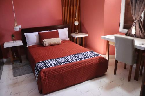 纳米贝Casa 2的一间卧室配有红色的床和一张书桌