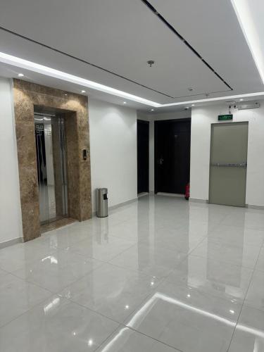 Sīdī Ḩamzahتوبال الماسي的一间空的宽大房间,有白色的地板和门