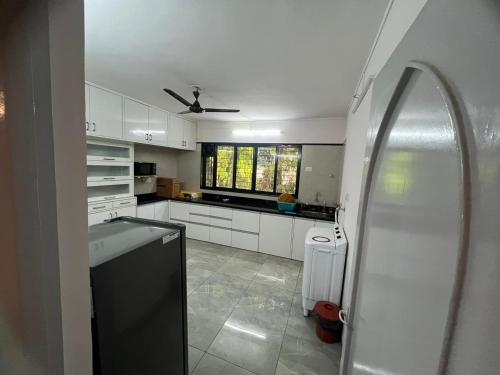 浦那Luxurious 2Bhk Fully Furnished apartment的厨房配有白色橱柜和吊扇