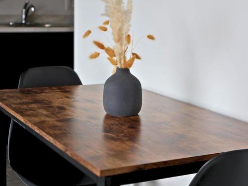 里穆斯基Logîtel Rimouski的一张黑花瓶坐在木桌前