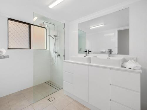 金斯克里福Ocean Outlook on Marine Parade的白色的浴室设有2个盥洗盆和淋浴。
