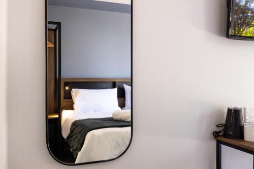 罗托鲁瓦Haka House Rotorua的卧室内的镜子反射着一张床