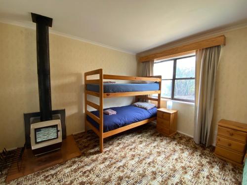 金德拜恩The Vintage Flat - Retro Charm in Tyrolean Village的一间卧室设有两张双层床和一个壁炉