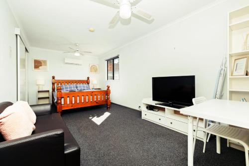 West Richmond1 BR Granny Flat near Airport的客厅配有婴儿床和电视。