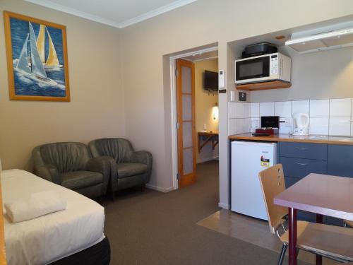 图朗伊Tongariro Junction Accommodation的一间设有厨房的房间和一间带一张床的客厅