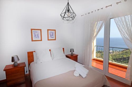卡尼索Vista Reis Magos的一间卧室设有一张床和一个大窗户