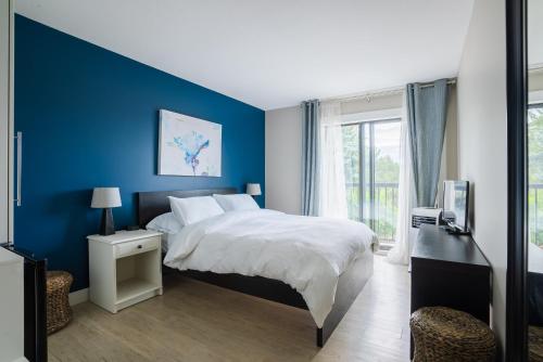 基洛纳Crawford View的蓝色的卧室设有床和窗户