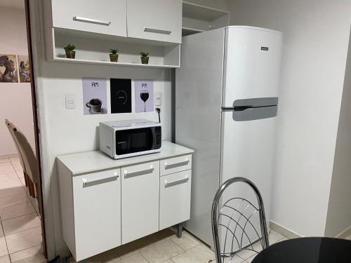 阿拉沙Apartamento até 8 pessoas Araxá Ótima localização的厨房配有白色冰箱和微波炉