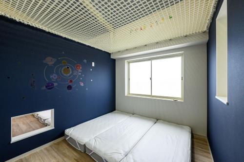 京丹后市子どもがおもいっきり楽しめる一軒家　taiza child的一间卧室配有一张蓝色墙壁的床