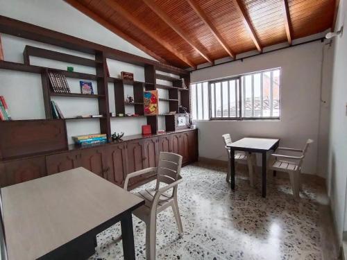 麦德林Casa Nogal 76的客房设有2张桌子和椅子以及窗户。