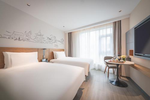 南京南京新街口逸扉酒店的酒店客房设有两张床和电视。