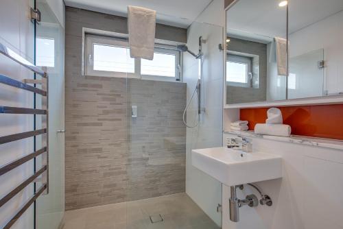 悉尼Cosy 1-Bedroom Apartment Close to the City的一间带水槽和淋浴的浴室