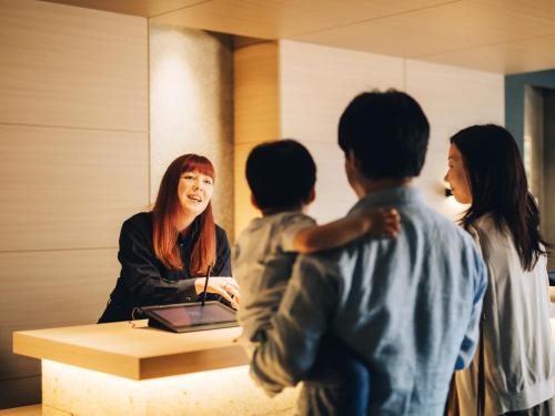 东京美满如家酒店 东京 赤坂的一名妇女站在桌子上,有四个孩子