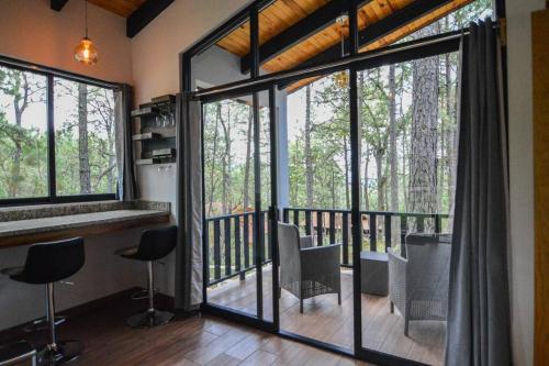 马萨米特拉Cabaña Mirtus的客房设有带椅子和窗户的阳台。