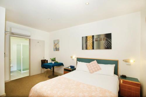阿德莱德CBD premium location Studio的酒店客房,配有一张床和一张蓝色椅子