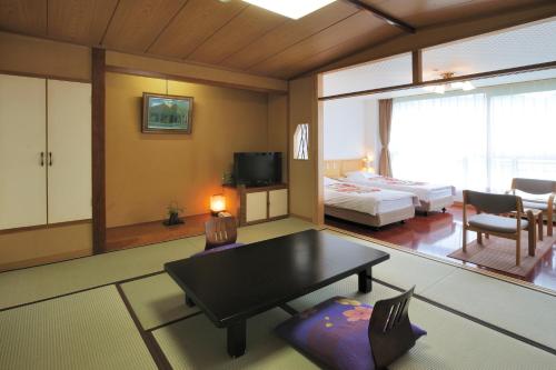 汤泽町汤泽大酒店 的客厅设有一张床和一张桌子