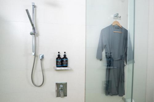 马六甲The Straits Melaka by Perfect Host的带淋浴和墙上浴袍的浴室