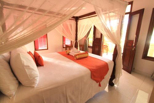 特贾库拉波恩西阿纳度假酒店的一间卧室配有一张带天蓬的大型白色床