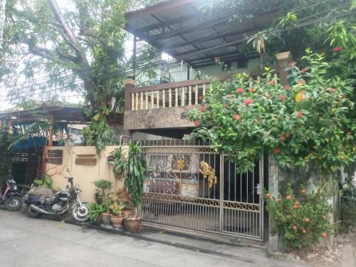 曼谷Bangkok Hotel Place的一座房子,有门,一些植物和摩托车