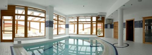 布拉格布拉托夫公寓及健康酒店的一座大型游泳池,位于一座带窗户的建筑内